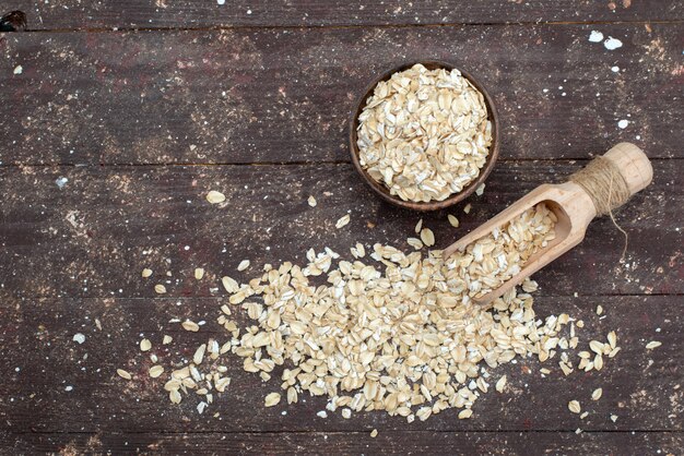 Draufsicht rohes Haferflocken hell gefärbt auf braun, Cracker Snack Brot Trockenmahlzeit nützliche Gesundheit Frühstück