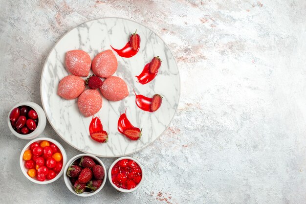 Draufsicht rosa Erdbeerkuchen kleine Süßigkeiten innerhalb Platte auf weißem Schreibtisch Kuchen Zuckerplätzchen Tee Keks süß