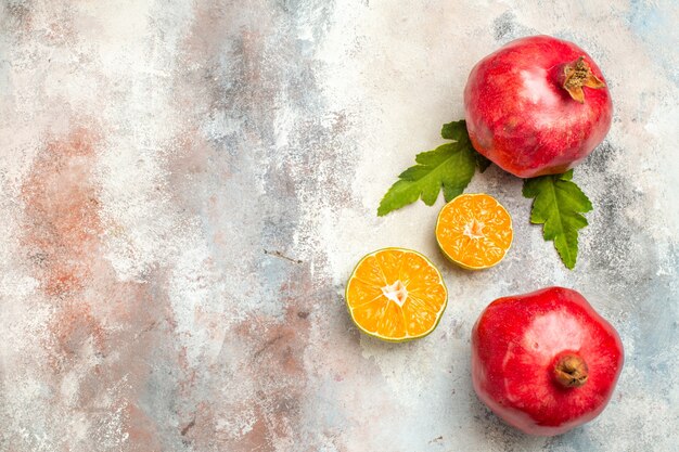 Draufsicht rote Granatäpfel Zitronenscheiben auf nackter Oberfläche mit freiem Raum