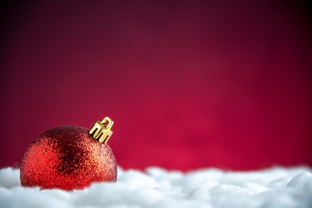 Draufsicht rote Weihnachtsbaumkugel auf rot isoliertem Tisch mit freiem Platz