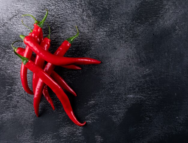 Draufsicht roter Chili-Pfeffer mit Kopierraum rechts auf schwarzem Stein horizontal