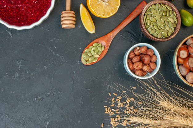 Draufsicht rotes Fruchtgelee mit Erdnüssen und Rosinen auf dem dunkelgrauen Konfitüre-Nuss-Teig-Kuchen-Keks