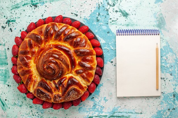 Draufsicht runde köstliche Torte mit frischen roten Erdbeeren auf hellblauer Oberfläche