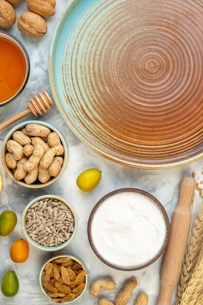 Draufsicht rundes Tablett mit Nüssen Mehl Brot Eier und Milch auf dem weißen Hintergrund Foto Farbe Kuchen Kuchen Hotcake Brötchen Keks Teig