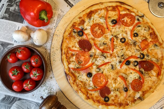 Draufsicht Salami-Pizza auf einem Tablett mit Pilzen und Tomaten mit bulgarischem rotem Pfeffer
