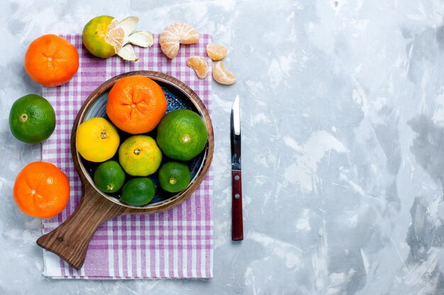 Draufsicht saure frische Mandarinen mit Zitronen auf hellweißer Oberfläche