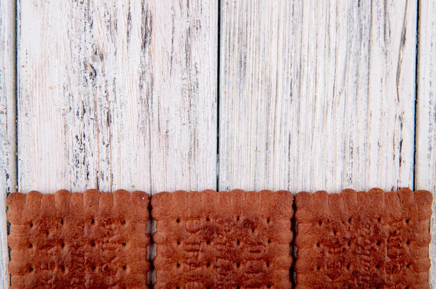 Kostenloses Foto draufsicht schokoladencracker auf der unterseite mit kopienraum auf weißem hölzernem hintergrund
