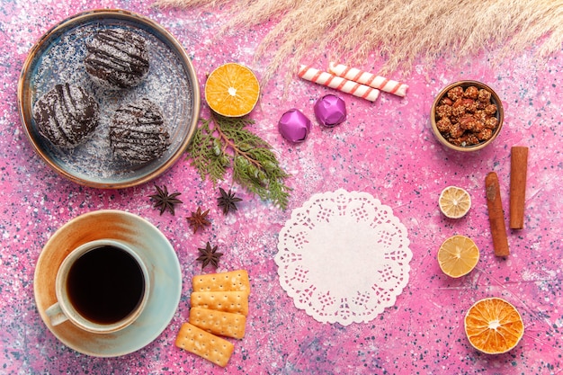 Draufsicht Schokoladenkuchen mit Tasse Tee auf hellrosa