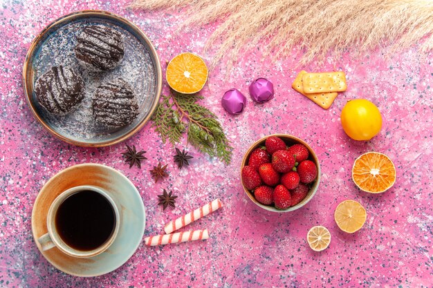 Draufsicht Schokoladenkuchen mit Tasse Tee auf Rosa