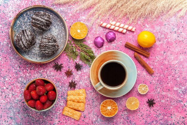 Draufsicht Schokoladenkuchen mit Tasse Tee auf Rosa