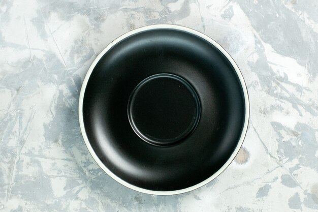 Draufsicht schwarze Platte leere Runde gebildet auf einer weißen Oberflächenplatte Glaslebensmittelfarbe