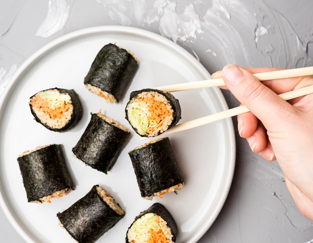 Kostenloses Foto draufsicht-sortiment von sushi-rollen mit stäbchen