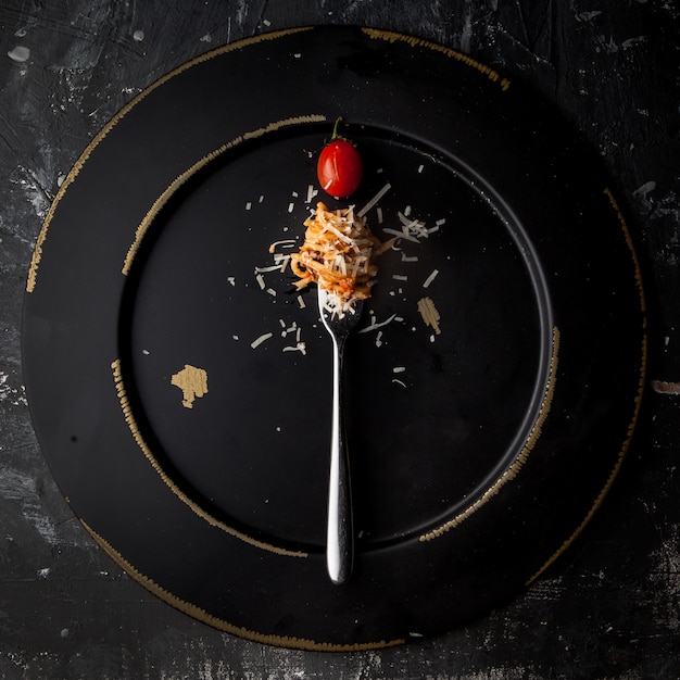 Kostenloses Foto draufsicht spaghetti mit gabel und tomaten- und ricotta-käse in runder schwarzer platte