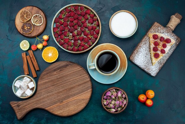 Draufsicht-Stück Kuchen gebacken süß mit Himbeeren und Tee auf dem dunklen Schreibtisch Beerenkuchen Kuchen backen Keks