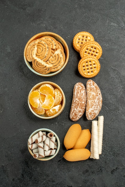 Draufsicht süße Kekse mit Früchten und Bonbons auf dem dunklen Hintergrund