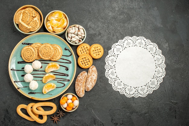 Draufsicht süße Kekse mit Keksen und Bonbons auf grauem Hintergrund