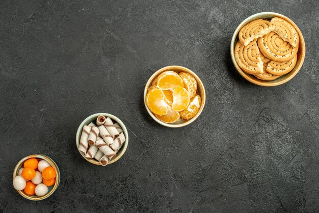 Draufsicht süße Kekse mit Mandarinen auf dunklem Hintergrund