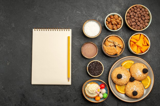 Draufsicht süße Kekse mit Pommes und Orangenscheiben auf dunkler Oberfläche Fruti Cookies Keks süßer Kuchen Kuchen