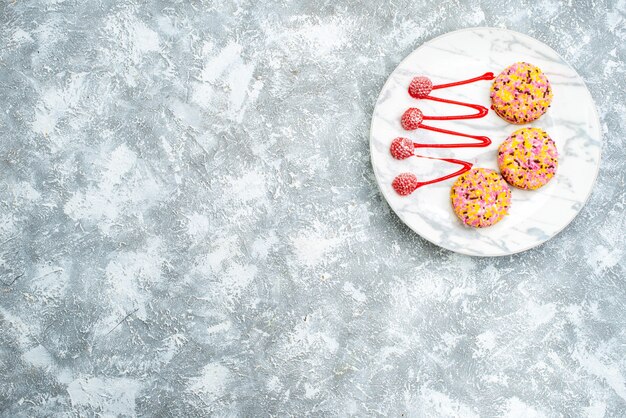 Draufsicht süße Kekse mit Sahne auf weißem Hintergrund Plätzchenkekszuckerkuchenkuchen süßer Tee