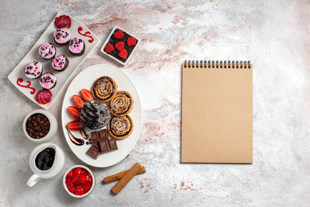 Draufsicht süße Kekse mit Schokoladenkuchen auf einem weißen Hintergrundplätzchenkeks süßer Kuchenzuckertee