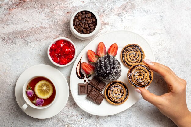Draufsicht süße Kekse mit Schokoladenkuchen und Tee auf weißem Hintergrund Kekskeks Zucker Tee süßer Kuchen