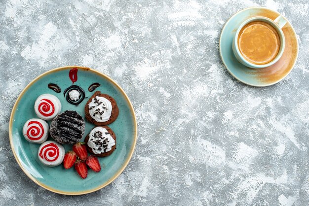 Draufsicht süße kleine Kuchen mit Tasse Kaffee auf weißem Hintergrundkuchenkuchen süßer Kekszuckerplätzchen