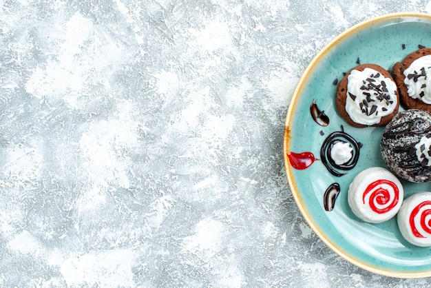 Kostenloses Foto draufsicht süße kleine kuchen verschiedene süße kekse auf hellweißem hintergrundkuchenkuchen süßer keksplätzchenzucker