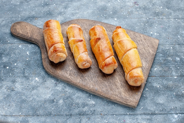 Draufsicht süße köstliche Armreifen mit Füllung auf dem grauen Holzschreibtisch süßer Zucker backen Gebäck