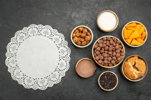 Draufsicht süße Nüsse mit Kakaoflocken und Cips auf dunkler Oberfläche Snack Milchmahlzeit Frühstücksnuss