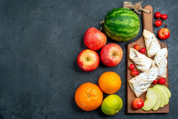 Draufsicht süßes fruchtiges Gebäck mit frischen Früchten auf dunkelgrauem Schreibtischfruchtkeks süßer Zuckerkuchen