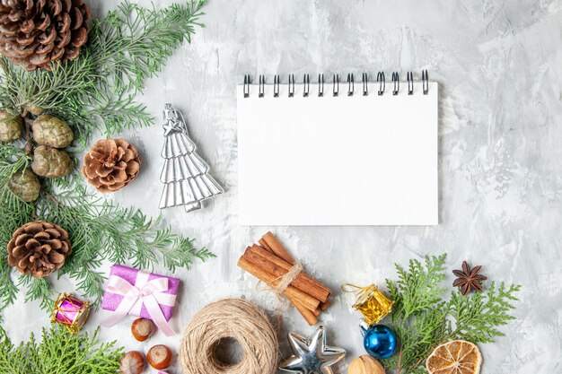 Draufsicht Tannenbaum Zweige Kegel Notebook auf grauem Hintergrund