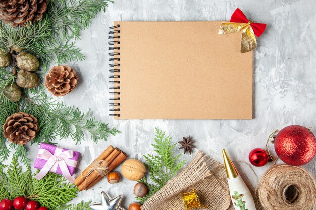 Draufsicht Tannenbaum Zweige Kegel Notebook auf grauem Hintergrund