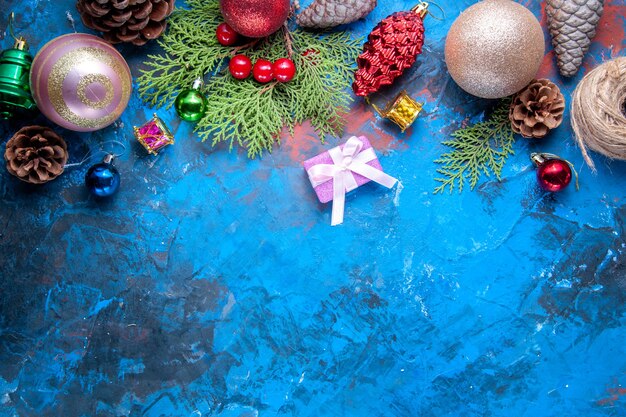 Draufsicht Tannenzweige Tannenzweige Kegel Weihnachtsbaum Spielzeug auf blauem Hintergrund