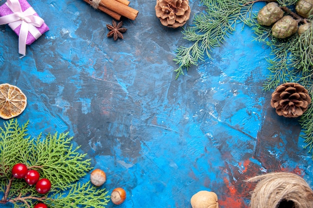 Draufsicht Tannenzweige Tannenzweige Kegel Weihnachtsbaum Spielzeug auf blauem Hintergrund