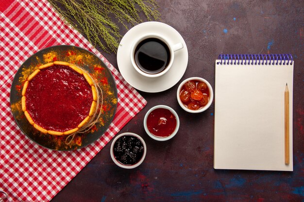 Draufsicht Tasse Kaffee mit köstlichem Dessertkuchen und Fruchtmarmeladen auf dunklem Schreibtisch süßer Fruchtkekskeks süß