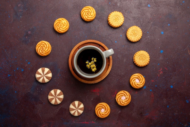 Draufsicht Tasse Kaffee mit verschiedenen Keksen auf dunklem Hintergrund Kekskekszuckerkuchen