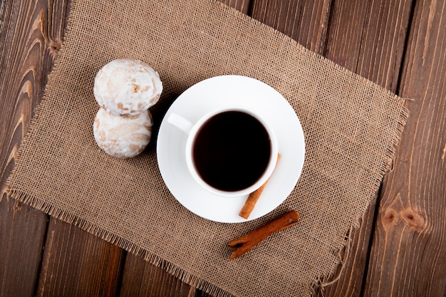 Draufsicht Tasse Kaffee mit Zimt und Lebkuchen auf Holztisch