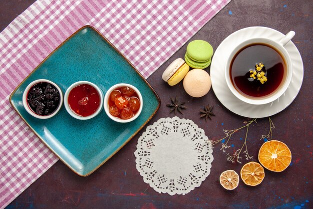 Draufsicht Tasse Tee innerhalb Platte und Tasse auf dunklem Hintergrund Tee trinken Farbfoto süß