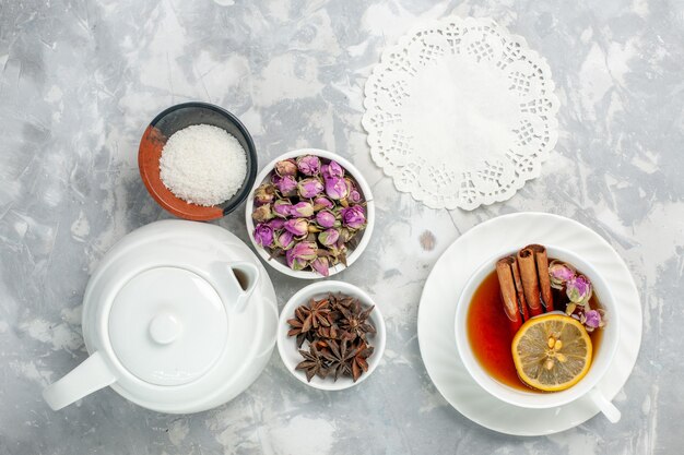 Draufsicht Tasse Tee mit Blumen und Kessel auf weißer Oberfläche