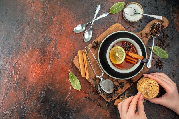 Draufsicht Tasse Tee mit frischem schwarzem Tee auf einem dunkelbraunen Hintergrund Aquarellzeremonie Tee Frühstücksgetränk Keksfoto