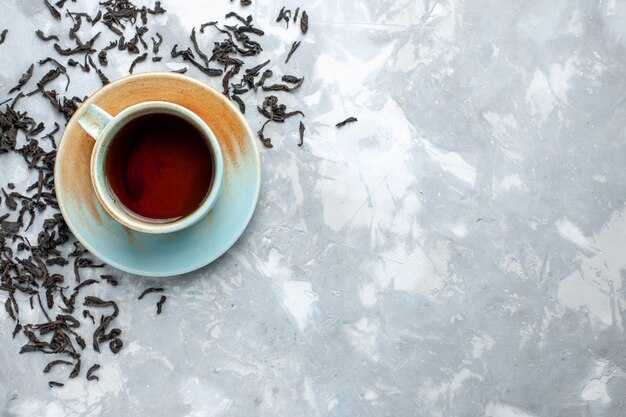 Draufsicht Tasse Tee mit frischen getrockneten Teekörnern auf dem Leuchttisch, Teegetränk Frühstück