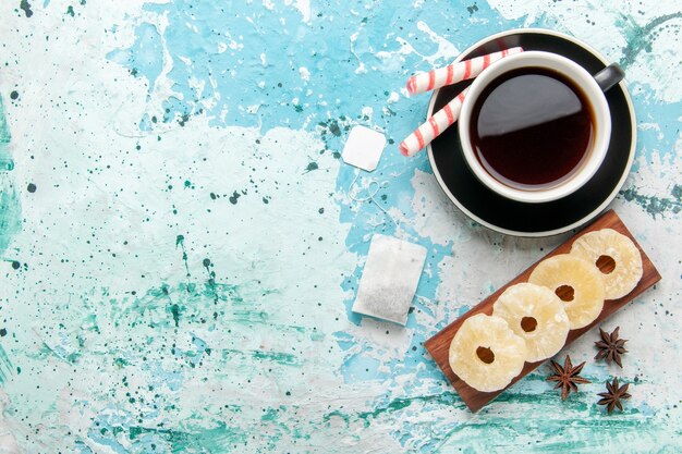 Draufsicht Tasse Tee mit getrockneten Ananasringen auf der blauen Oberfläche