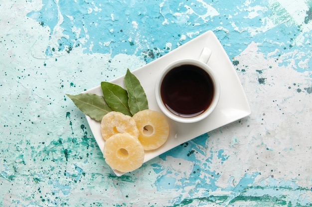 Draufsicht Tasse Tee mit getrockneten Ananasringen auf hellblauer Oberfläche