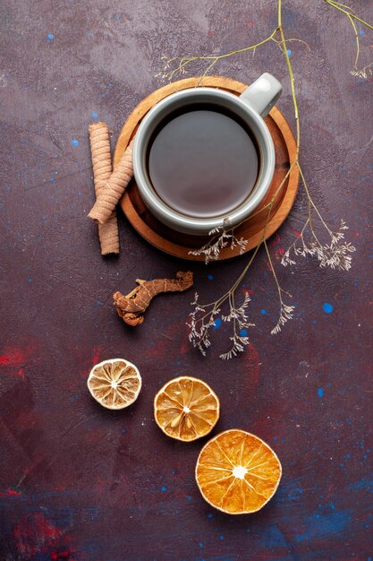 Draufsicht Tasse Tee mit Keksen auf dunklem Schreibtisch Tee trinken süßen Zucker