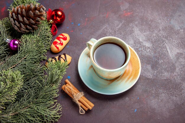 Draufsicht Tasse Tee mit Keksen auf dunklem Schreibtisch Teebiskuitfarbe