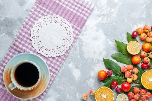 Draufsicht Tasse Tee mit Kirschen und anderen Früchten auf dem hellen Schreibtischfrucht frischen milden Tee