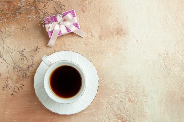 Draufsicht Tasse Tee mit kleinem Geschenk