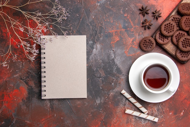 Draufsicht Tasse Tee mit Schoko-Keksen auf dunklen Tischkeks-Tee-Keksen