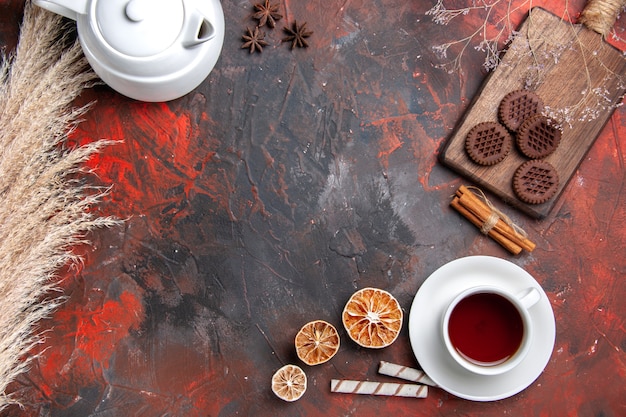 Draufsicht Tasse Tee mit Schokokeksen auf dunklem Tischteekeks