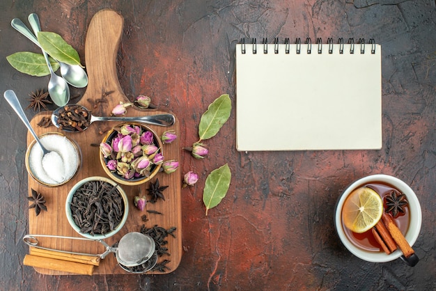 Draufsicht Tasse Tee mit schwarzem Tee und getrockneten Blumen auf einem dunkelbraunen Hintergrund Teefruchtaquarellfrühstücksgetränk-Zeremoniefoto